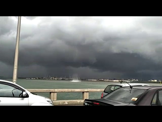As bewildered motorists look on, water spout crosses over Penang Bridge